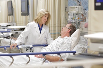 image of a doctor talking to a patient who is in a hospital bed